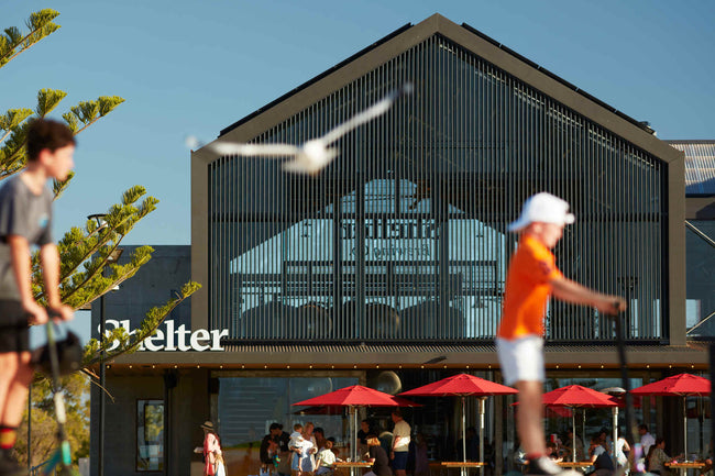 Photo of Shelter Brewing Co. with seagull and kids on scooters blurred in foreground